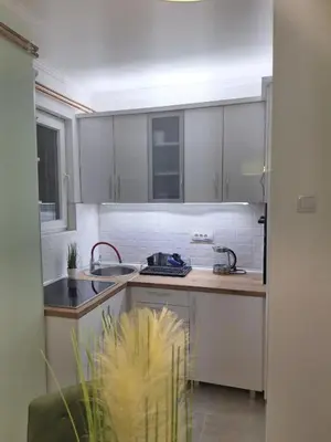 a kitchen with white cabinets and a sink at Apartman Nikola Vukosavljevic in Kruševac