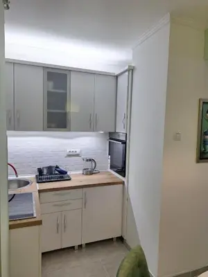 a kitchen with white cabinets and a sink at Apartman Nikola Vukosavljevic in Kruševac