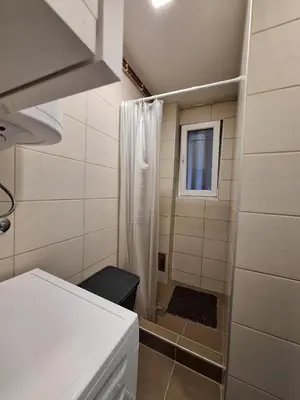 a small bathroom with a shower with a window at Apartman Nikola Vukosavljevic in Kruševac