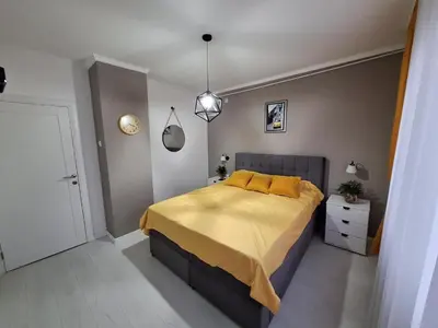 a bedroom with a large bed with yellow pillows at Apartman Nikola Vukosavljevic in Kruševac