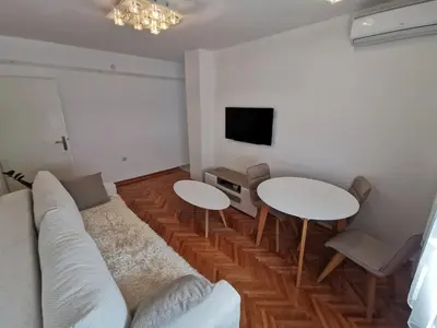 a living room with a couch and two tables and a tv at Lunjica in Niš