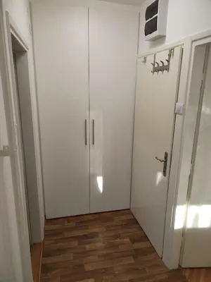 a white closet with a door in a room at Lunjica in Niš