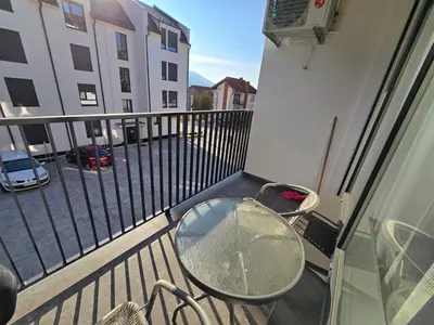 a balcony with a glass table on a balcony at Apartman Nikolić in Soko Banja