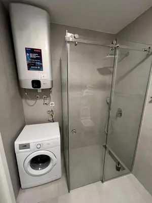 a shower stall with a washing machine in a bathroom at LiboroPlanet in Niš