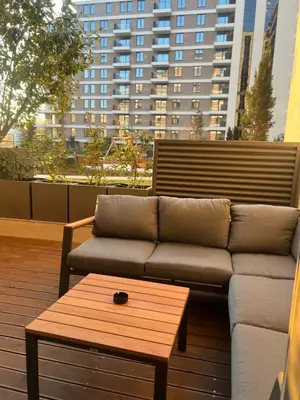 a couch and a coffee table on a balcony with a building at LiboroPlanet in Niš