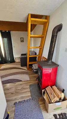 a living room with a stove and a bunk bed at Goč Sunčani breg in Stanišinci