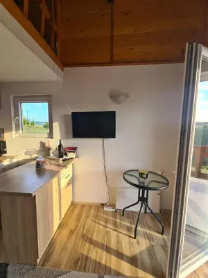 a kitchen with a table and a small table with a window at Goč Sunčani breg in Stanišinci