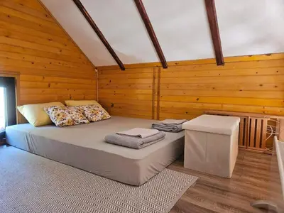 a bedroom with a bed in a room with wooden walls at Goč Sunčani breg in Stanišinci