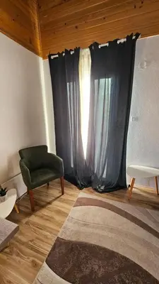 a living room with a window and a green chair at Goč Sunčani breg in Stanišinci