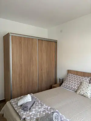 a bedroom with a bed and a wooden cabinet at Jasmina apartman in Soko Banja