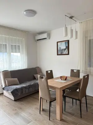 a living room with a table and a couch at Jasmina apartman in Soko Banja