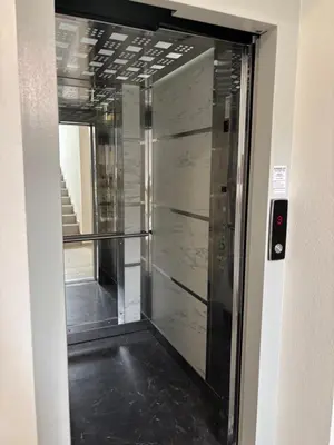 a glass elevator door in a building with a staircase at Jasmina apartman in Soko Banja