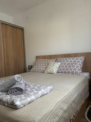 a bedroom with a large bed with a wooden headboard at Jasmina apartman in Soko Banja