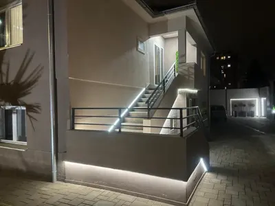 a set of stairs with lights on the side of a building at California Apartments in Niš