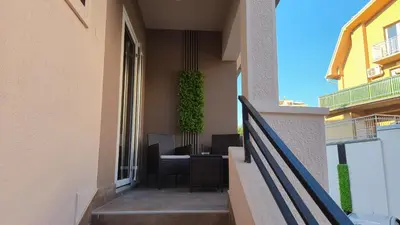 a balcony of a building with a table and chairs at California Apartments in Niš