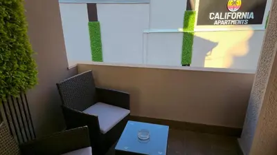 a waiting area with two chairs and a table at California Apartments in Niš