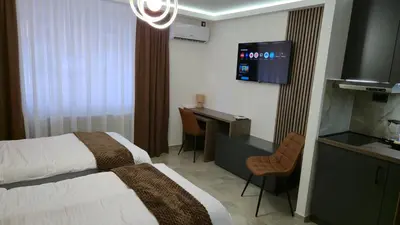 a hotel room with a bed and a desk at California Apartments in Niš