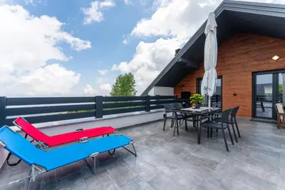 a patio with a table and chairs and an umbrella at Vision apartmani Goč in Goč