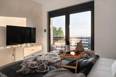 a living room with a television and a table with a bottle of wine at Vision apartmani Goč in Goč