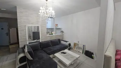 a living room with a black couch and a chandelier at Kristal in Niš
