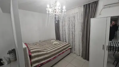 a room with a bed with a chandelier in it at Kristal in Niš