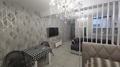 a living room with a chandelier and a table and chairs at Kristal in Niš