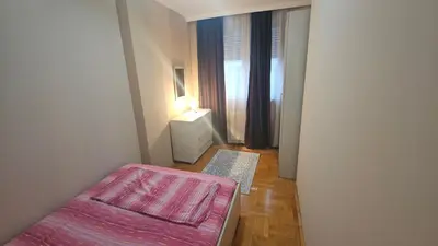a small bedroom with a bed and a window at Riverside rest in Niš