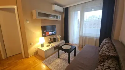 a small living room with a bed and a television at Riverside rest in Niš