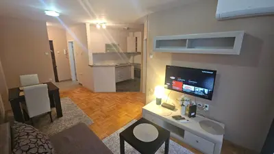 a living room with a desk with a tv on a wall at Riverside rest in Niš