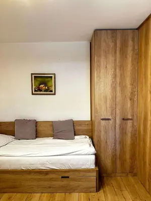 a bedroom with a bed and a wooden cabinet at Konaci Kopaonik 28 in Kopaonik