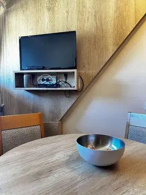 a bowl on a table with a television on a wall at Konaci Kopaonik 28 in Kopaonik