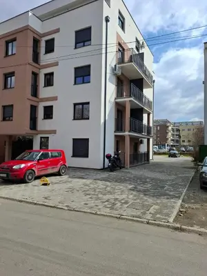 a red car parked in front of a building at Apartman STAR Vrnjačka Banja in Vrnjci