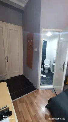 a room with a bathroom with a toilet and a mirror at Top rooms in Niš