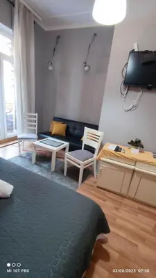 a living room with a couch and a table and chairs at Top rooms in Niš