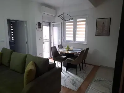 a living room with a green couch and a table at Apartman Biser Vranja - FREE PARKING - CITY CENTER in Vranje