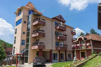 a building with balconies and a car parked in front at Spa & wellness Villa Garetov Konak in Prolomska Banja