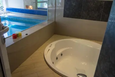 a bathroom with a sink and a swimming pool at Spa & wellness Villa Garetov Konak in Prolomska Banja