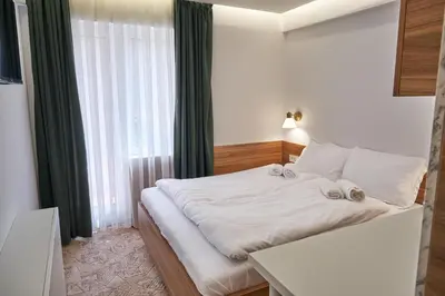 a bedroom with a bed and a large window at Spa & wellness Villa Garetov Konak in Prolomska Banja