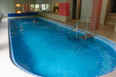 a person swimming in a large swimming pool at Spa & wellness Villa Garetov Konak in Prolomska Banja