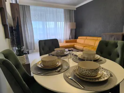 a dining room with a table and green chairs at Mina Lux in Paraćin