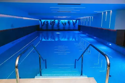 an empty swimming pool with stairs and blue lighting at Premium Planet Deluxe & SPA in Niš