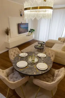 a living room with a round table and chairs at Premium Planet Deluxe & SPA in Niš