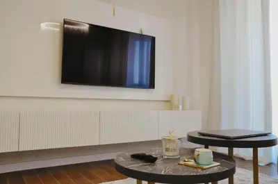 a living room with a flat screen tv on a wall at Premium Planet Deluxe & SPA in Niš