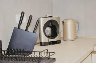 a kitchen counter with a coffee maker and utensils at Premium Planet Deluxe & SPA in Niš