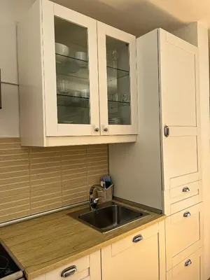 a kitchen with white cabinets and a sink at Mars apartman in Vrnjačka Banja