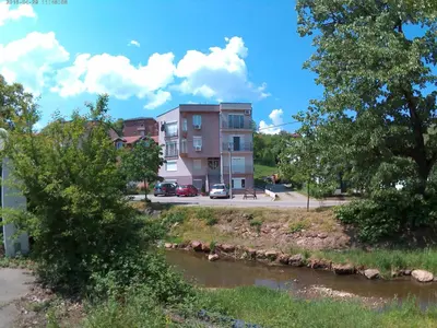 a building next to a river next to a street at Mars apartman in Vrnjačka Banja