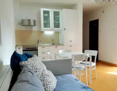 a kitchen and a dining room with a table and chairs at Mars apartman in Vrnjačka Banja