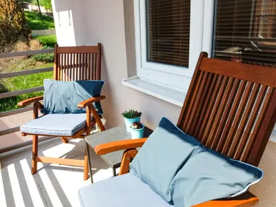 two rocking chairs sitting on a porch with a window at Mars apartman in Vrnjačka Banja