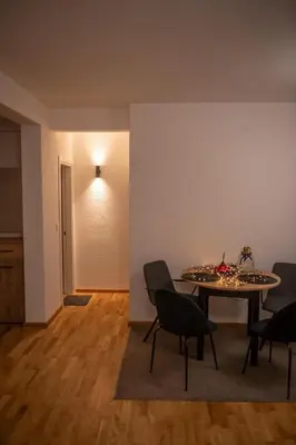 a dining room with a table and chairs in a room at Apartman Tasic in Vranje