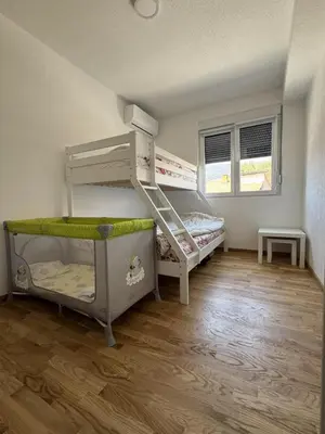 a room with two bunk beds and a wooden floor at Apartman Tasic in Vranje